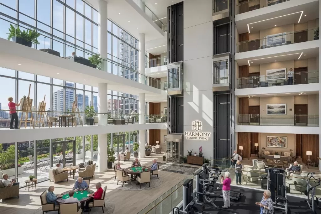 The interior of Harmony Senior Living, a modern assisted living facility with a multi-story atrium, large windows showing city views, activity areas including a gym, card tables, an art studio, and lounge spaces, where elderly residents are actively engaged in wellness and leisure activities.