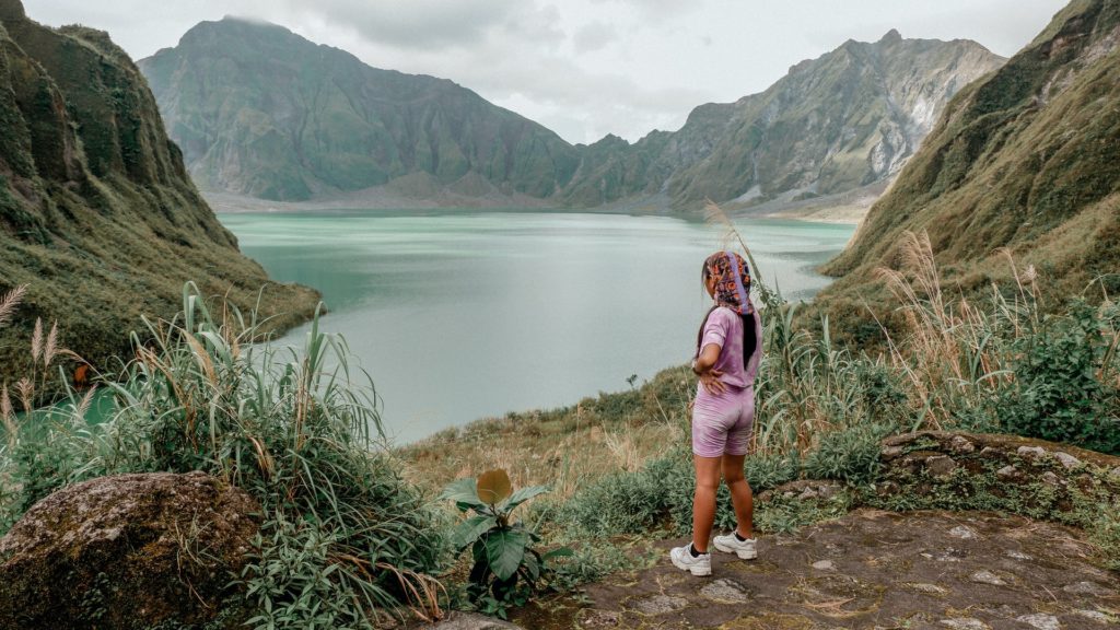 A Filipina woman stands on a cliff overlooking a lake in Botolan, Zambales.