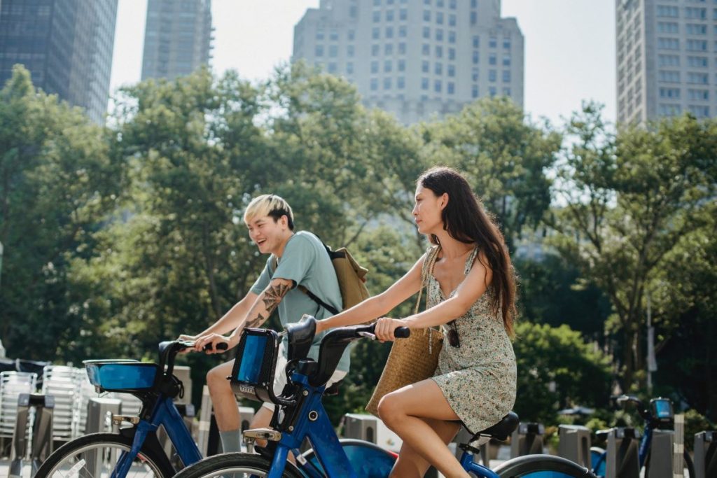 Two Asians riding a bike in a compact city designed township development.