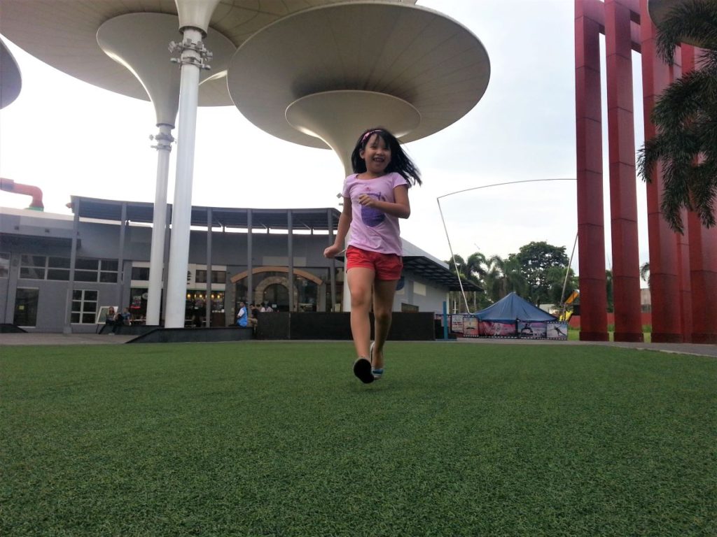 Little girl enjoying the green open space at Centris Mall, Quezon City