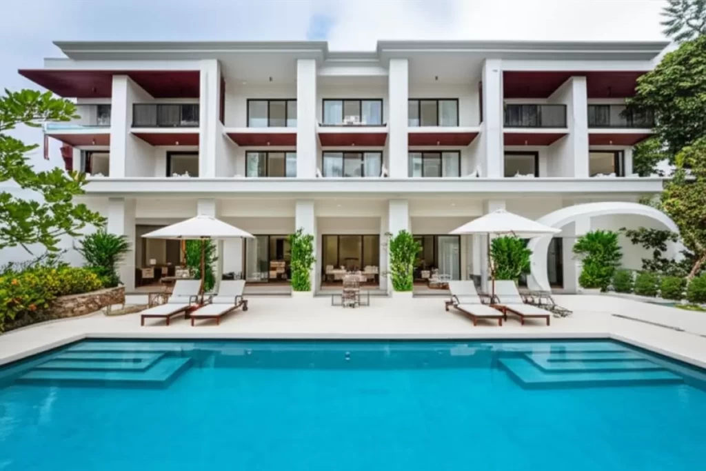 A tropical Philippine resort designed by architects for design excellence, featuring open-air courtyards, shaded balconies with deep overhangs, louvered facades, green roofs, and lush vertical gardens that enhance ventilation, provide shade, and integrate natural materials such as bamboo and stone within a climate-responsive and resilient structure.