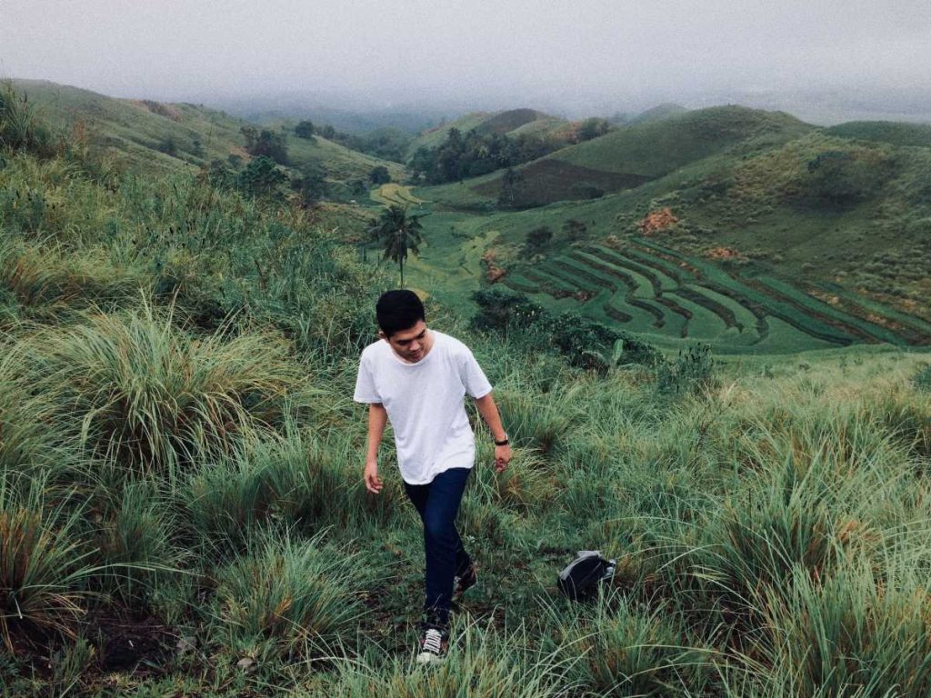 Man walking on hilly property with farming potential.