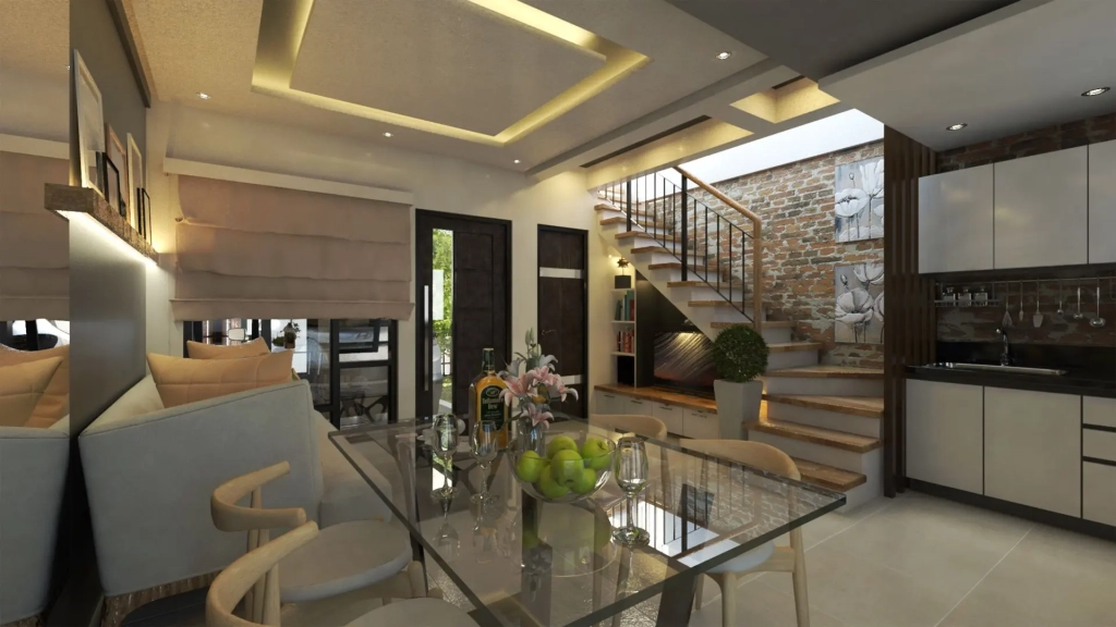 Interior view of modern townhouse with open-plan dining, kitchen, and living areas, exposed brick accent wall with staircase, layered ceiling with recessed lighting, glass dining table, light-toned chairs, and warm material palette.