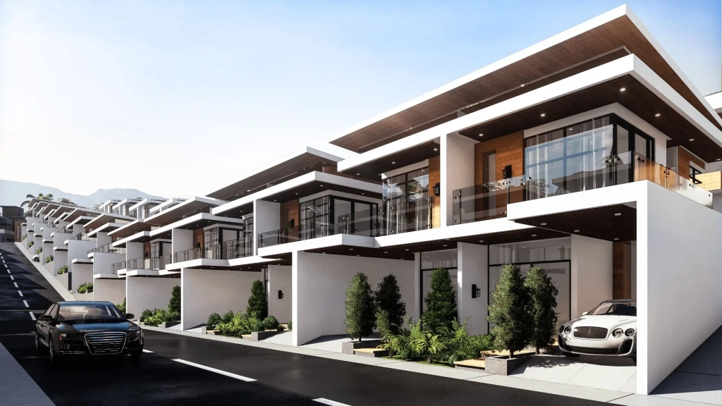 Modern residential row of single detached houses with cantilevered flat roofs, glass balcony railings, clean white facades, timber accent panels, landscaped front gardens, private driveways with parked luxury vehicles, and gently sloping paved street lined with tropical greenery.