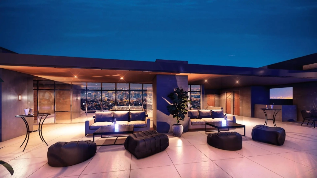 Modern rooftop amenity deck with lounge seating, bean bag chairs, planter boxes, city skyline views, contemporary canopy structure, warm ambient lighting, and open tiled flooring for outdoor gatherings.